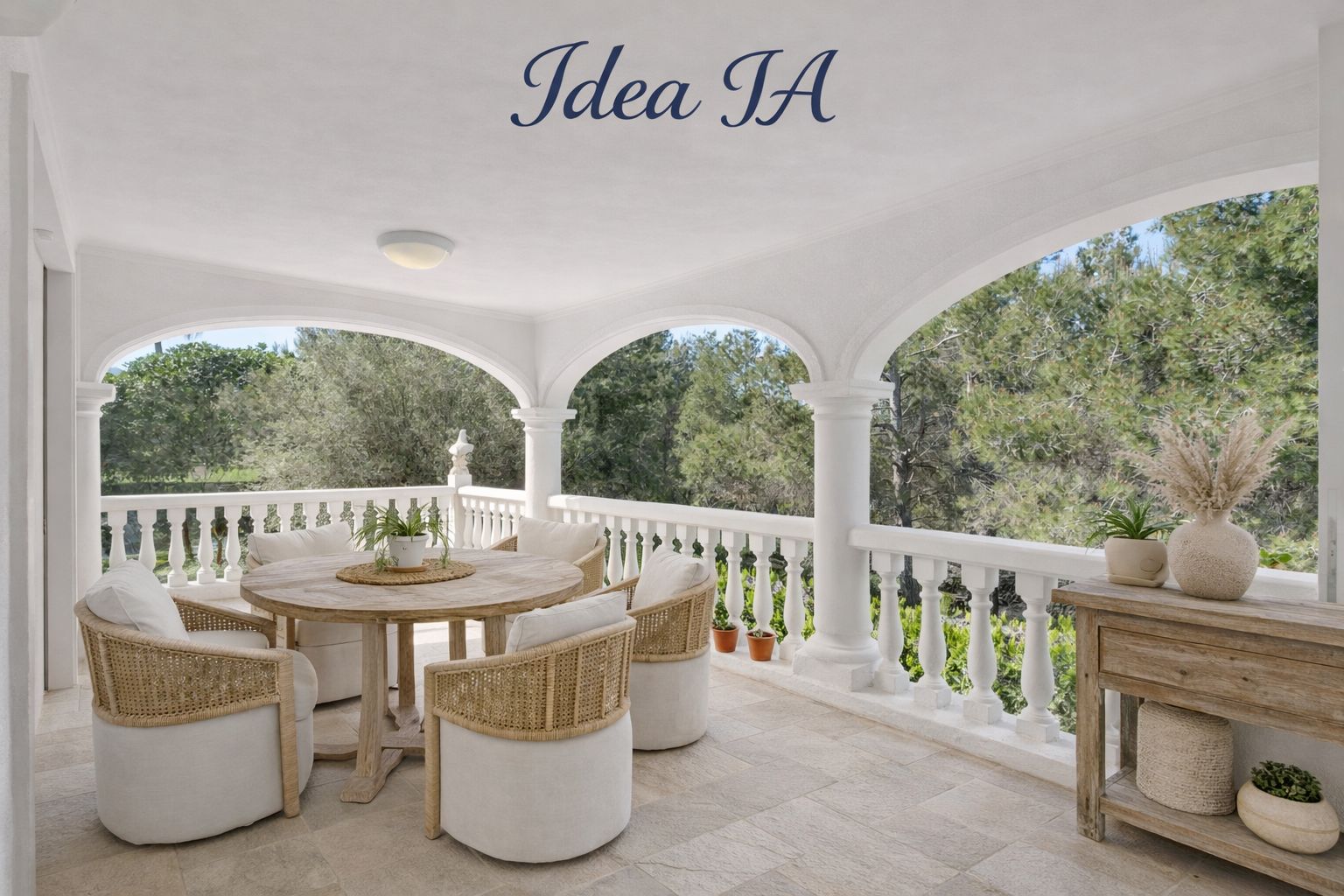 Terraza cubierta con arcos y balaustrada blanca, equipada con mesa de madera circular y sillones de mimbre con vistas directas a la vegetación mediterránea.