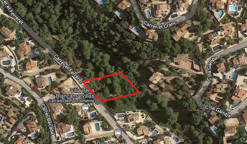 Vista aérea por satélite de la parcela de 826 m2 delimitada en rojo en la calle el Ferreret, rodeada de vegetación autóctona y villas residenciales con piscina.