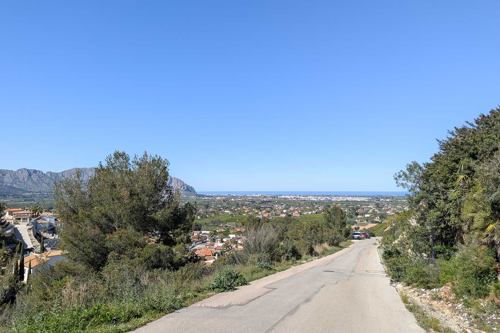 Entorno natural de Pedreguer con vistas a la costa y la silueta montañosa en un día soleado.