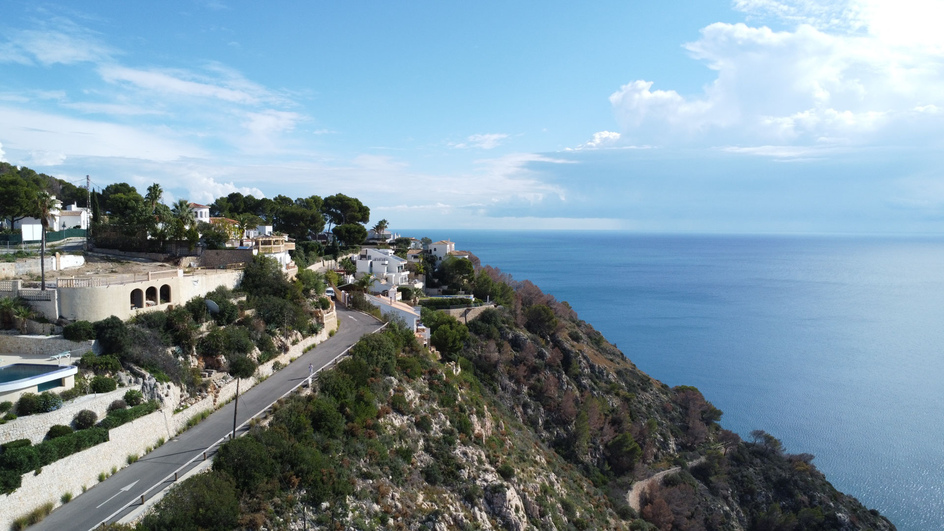 Vista aérea de la costa de la Granadella en Jávea, mostrando parcelas elevadas con vistas directas al mar Mediterráneo y acceso por carretera asfaltada.