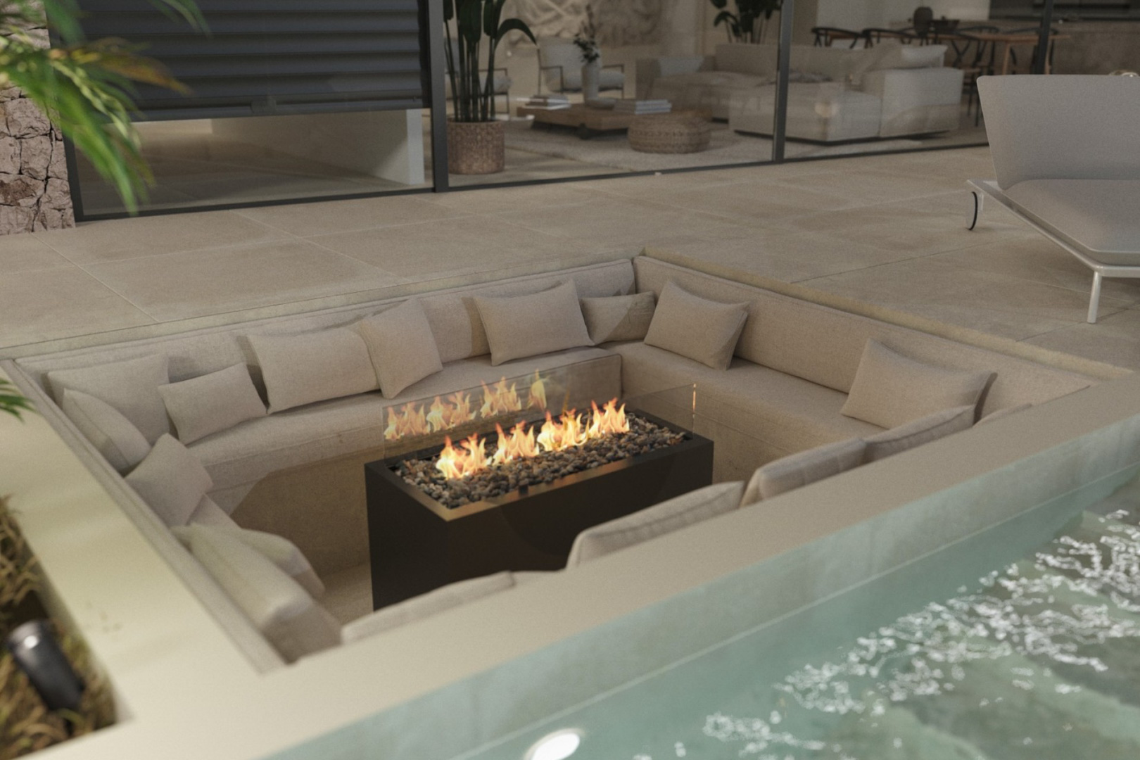 Zona de estar hundida en la terraza con sofás integrados y chimenea central de gas, situada junto a la piscina y conectada al salón.