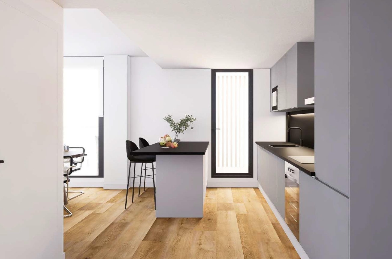 Cocina de diseño contemporáneo con isla central, encimera negra y taburetes. Incluye armarios grises minimalistas, electrodomésticos integrados y suelos de madera clara de Porcelanosa.