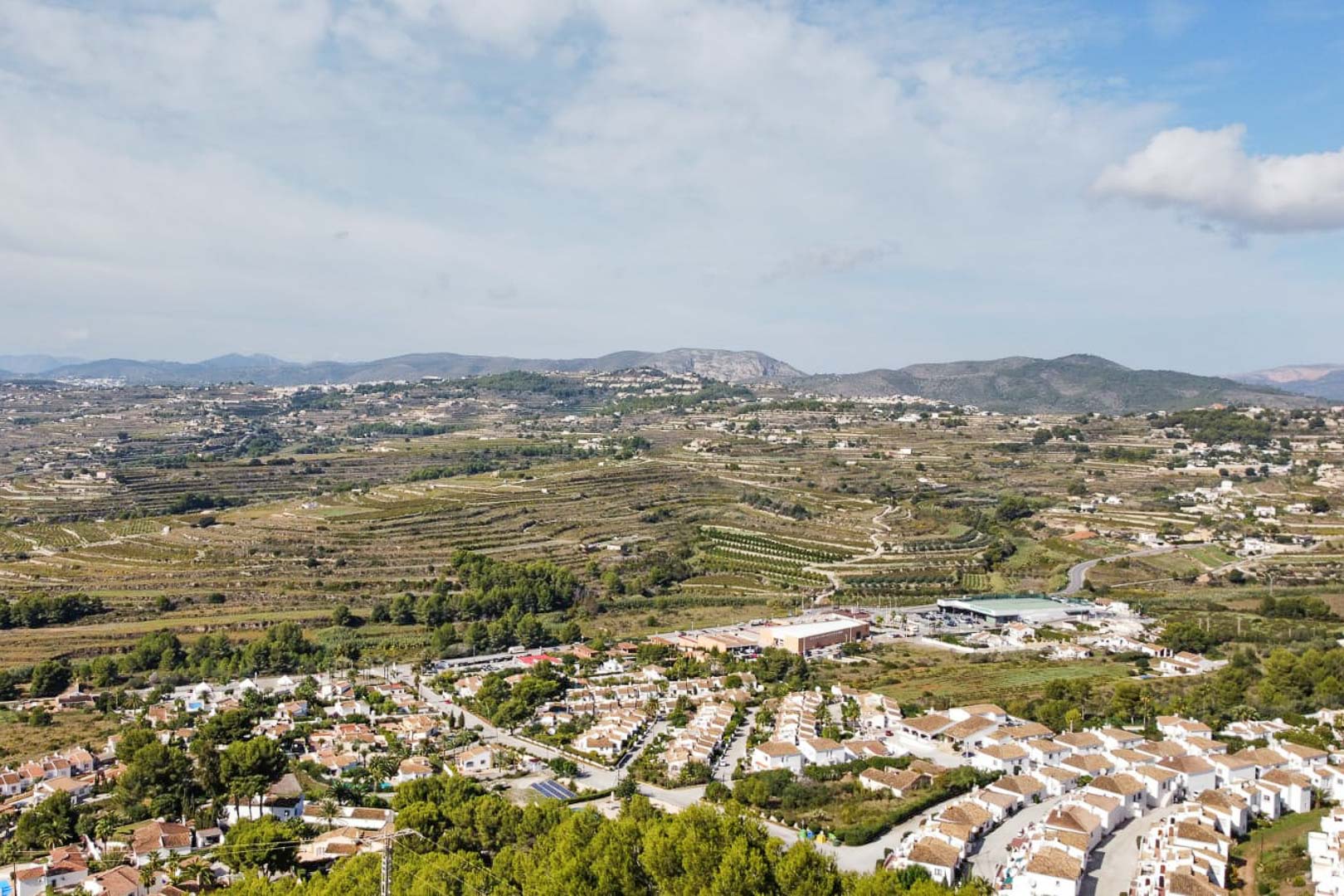 Vista aérea panorámica desde la zona de Paichi, mostrando el núcleo residencial de casas blancas y las características laderas abancaladas con las montañas al fondo.