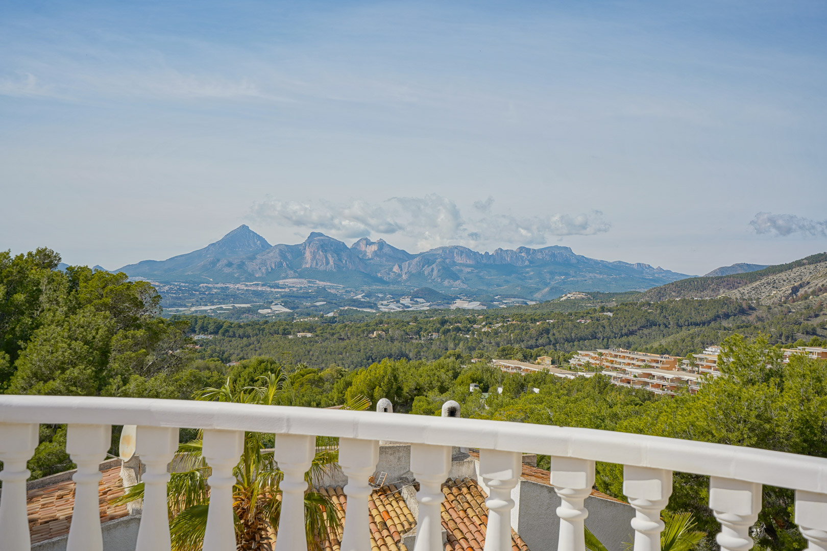 Terraza con balaustrada blanca clásica que ofrece vistas panorámicas ininterrumpidas hacia el Puig Campana y la cordillera de la Sierra Aitana.