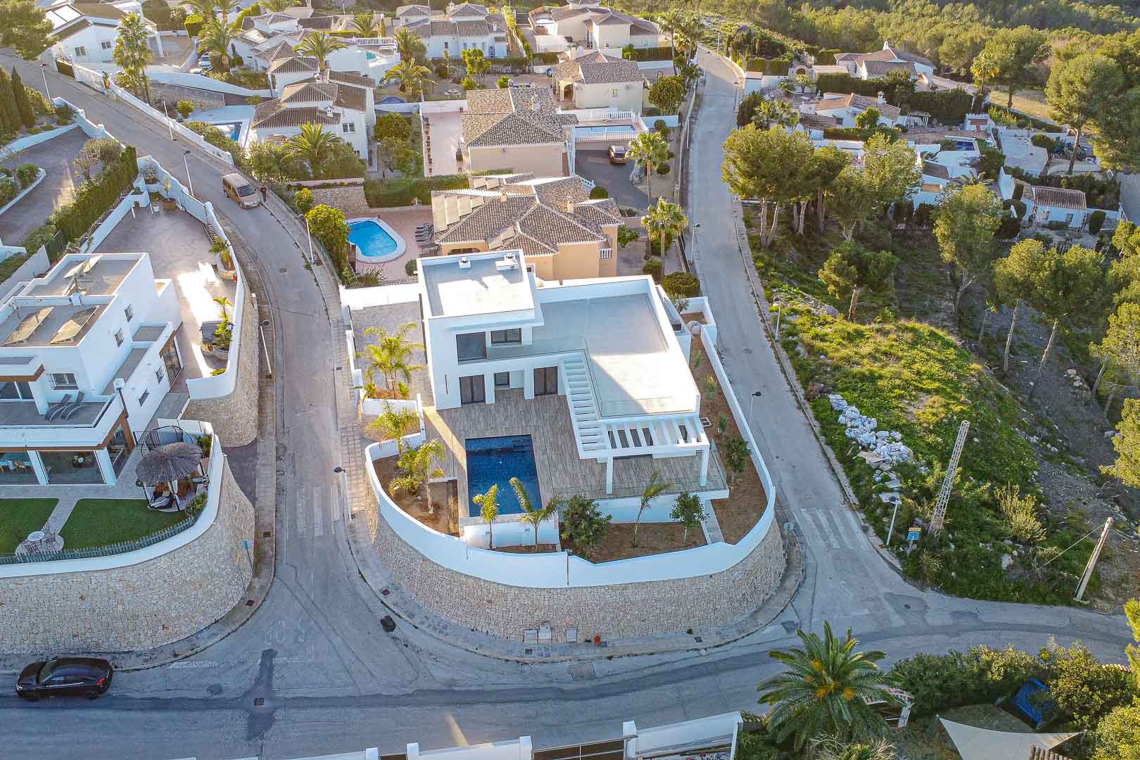 Vista aérea de villa moderna con piscina en Benimeit, Moraira. Diseño minimalista, terrazas y jardín mediterráneo.