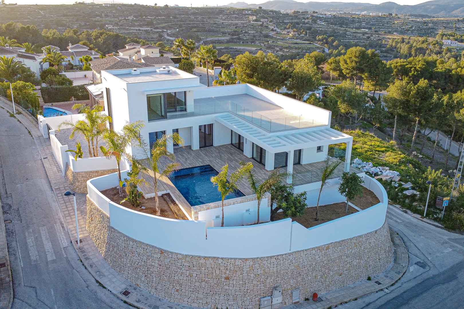 Vista aérea de villa moderna con piscina, terrazas y jardín mediterráneo en Benimeit, Moraira.
