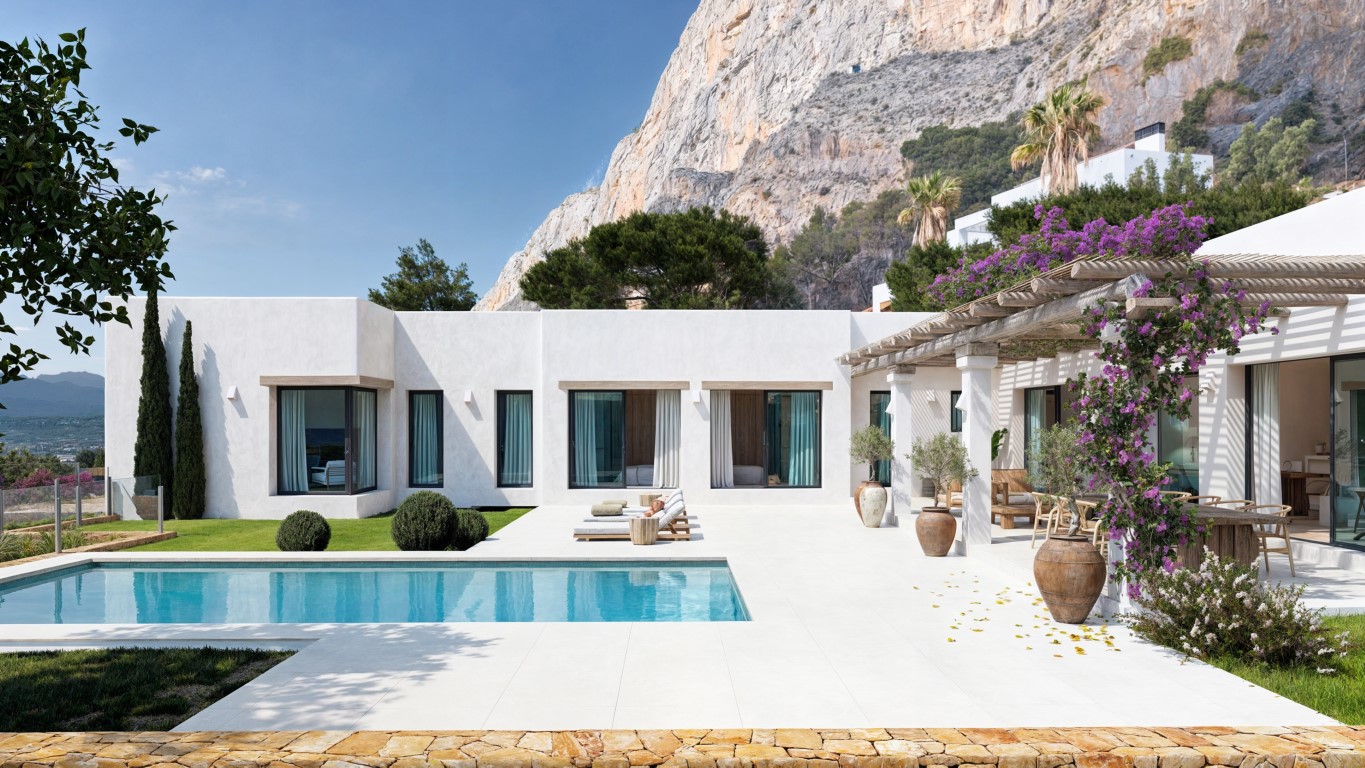Exterior de la villa con piscina rectangular, terraza blanca y pérgola de madera con buganvillas, situada bajo el imponente macizo del Montgó.