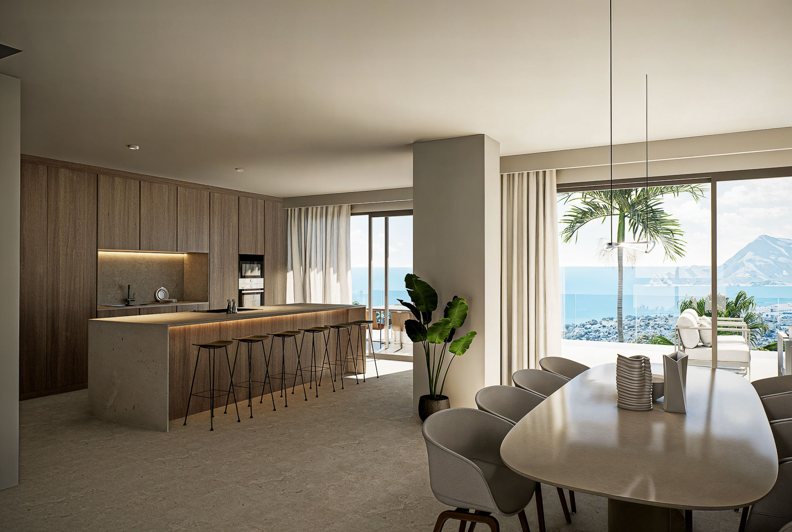 Cocina de diseño con isla central de piedra y comedor integrado, con ventanales de suelo a techo que ofrecen vistas panorámicas al mar Mediterráneo.