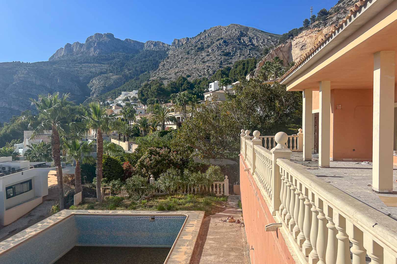 Terraza con balaustrada clásica y vistas despejadas a la Sierra de Bernia. La propiedad cuenta con una piscina privada y un entorno natural en la zona alta de Altea.
