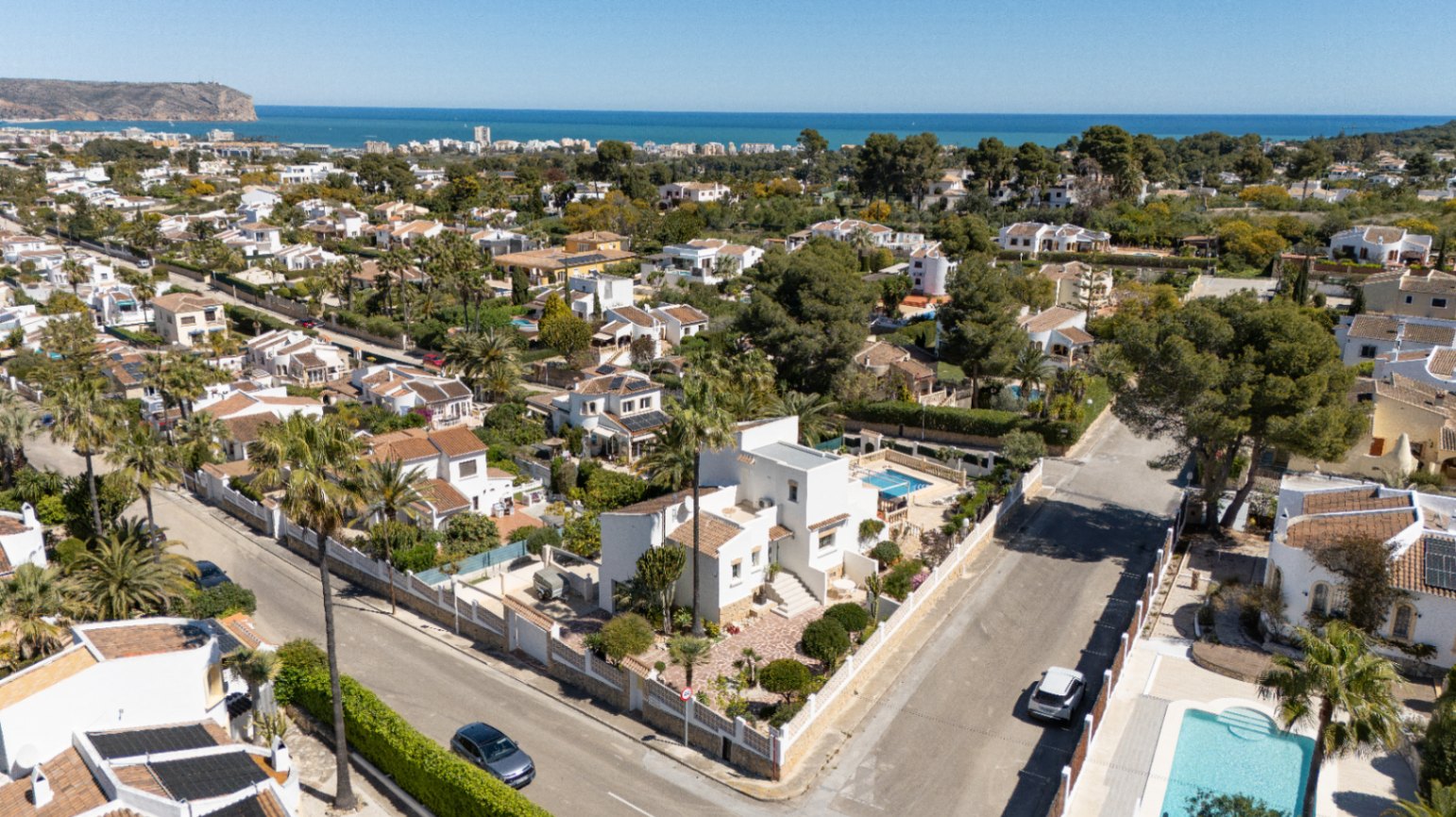 Vista aérea de la villa en Pinosol, Jávea, destacando su parcela de esquina con piscina privada, jardín mediterráneo y vistas panorámicas hacia el mar.