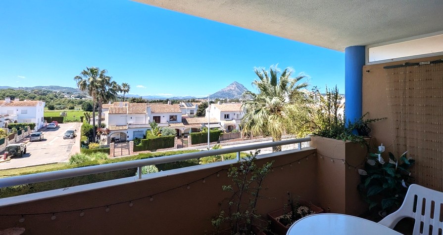 Terraza privada con barandilla metálica que ofrece vistas despejadas al macizo del Montgó y al entorno residencial de Jávea bajo un cielo despejado.