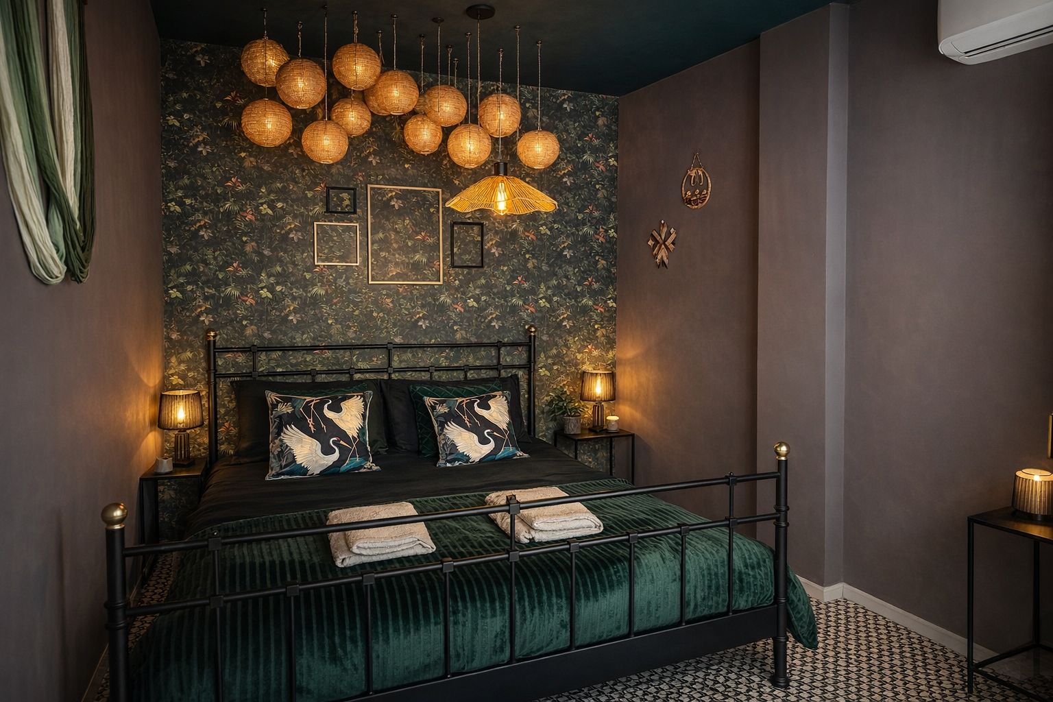 Dormitorio con cama de hierro forjado, ropa de cama verde esmeralda y lámparas colgantes de mimbre.