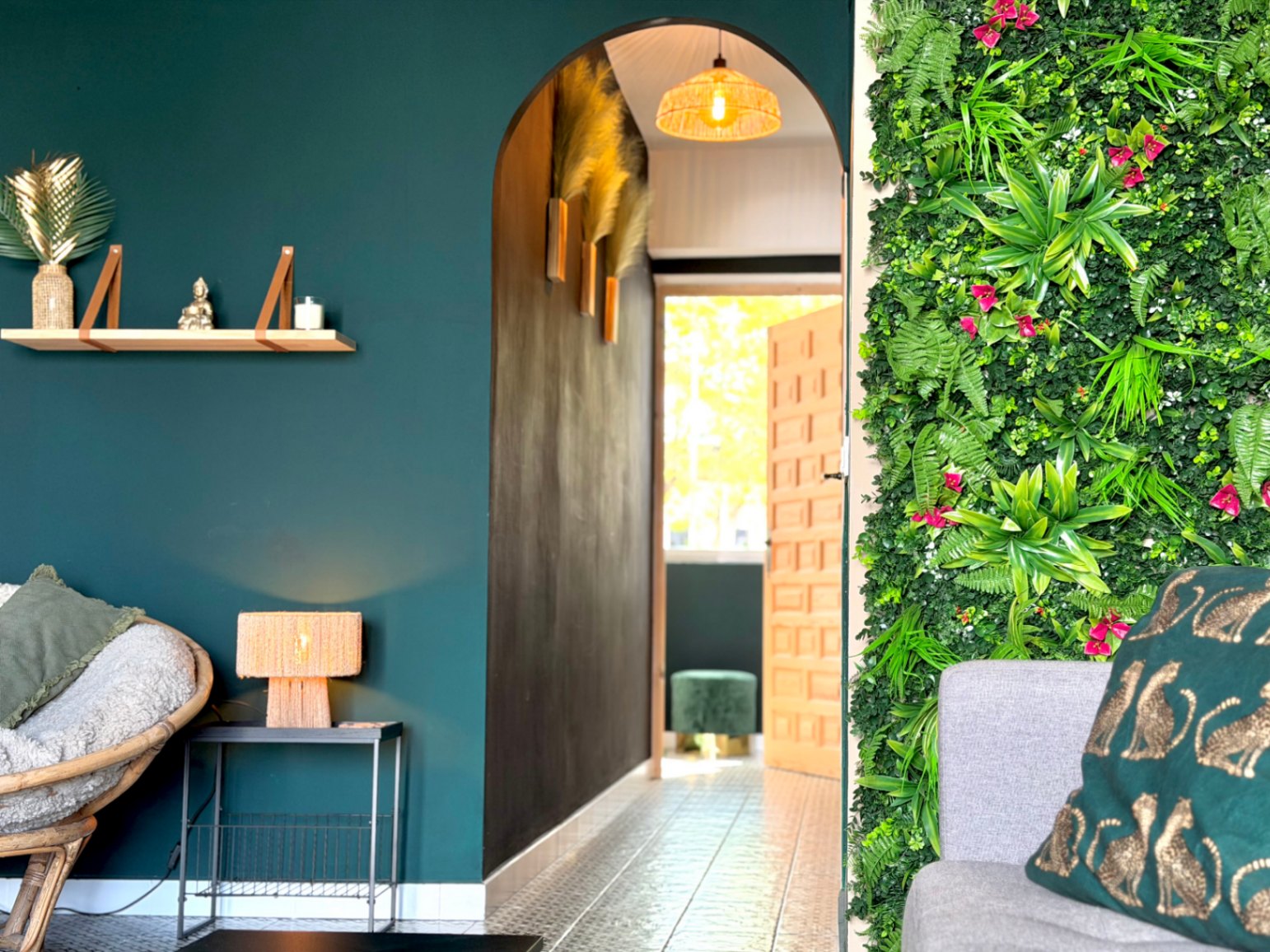 Interior con pared verde vertical, arco decorativo y estantería flotante en pared azul.