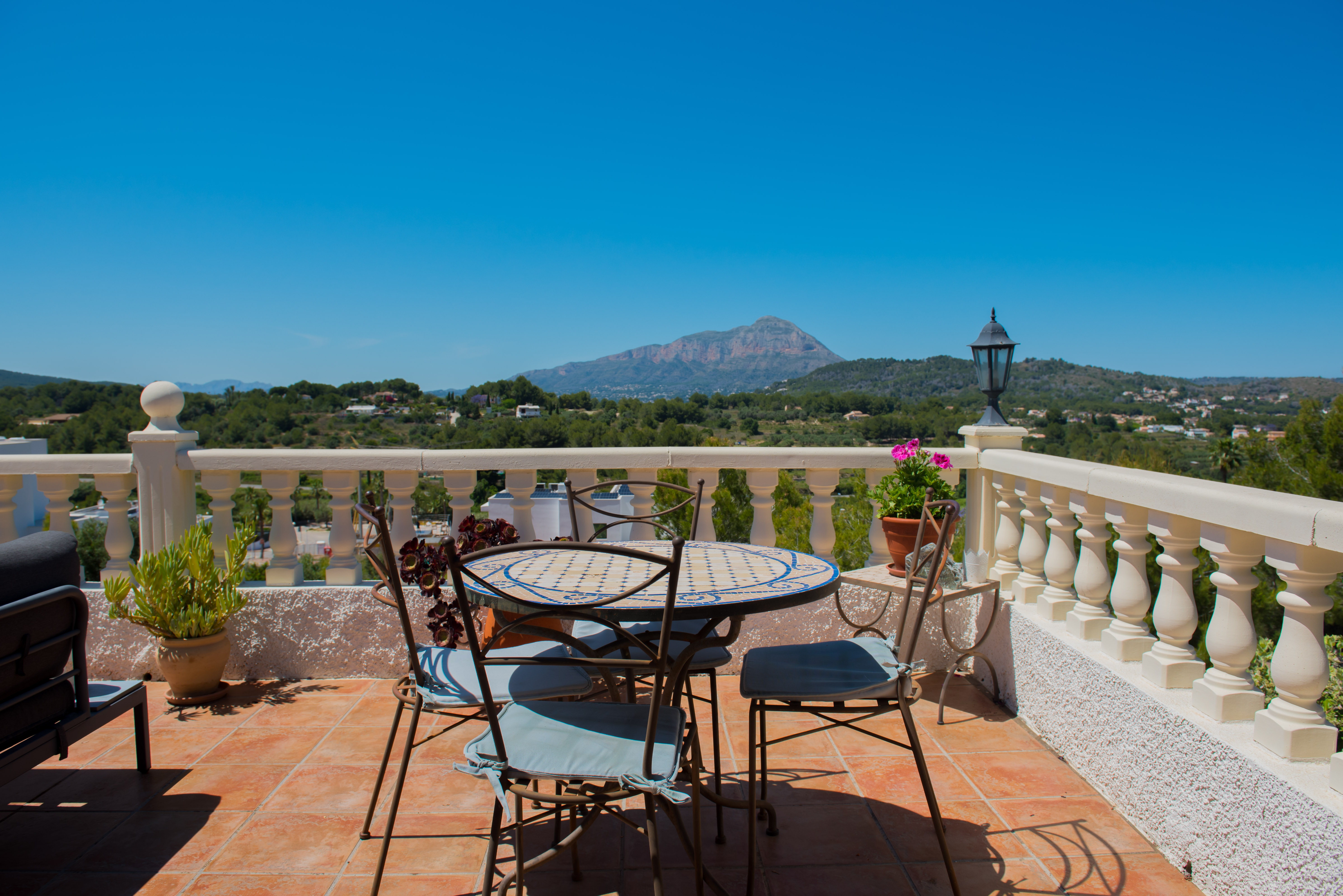 Terraza con mesa de mosaico y vistas a la montaña.