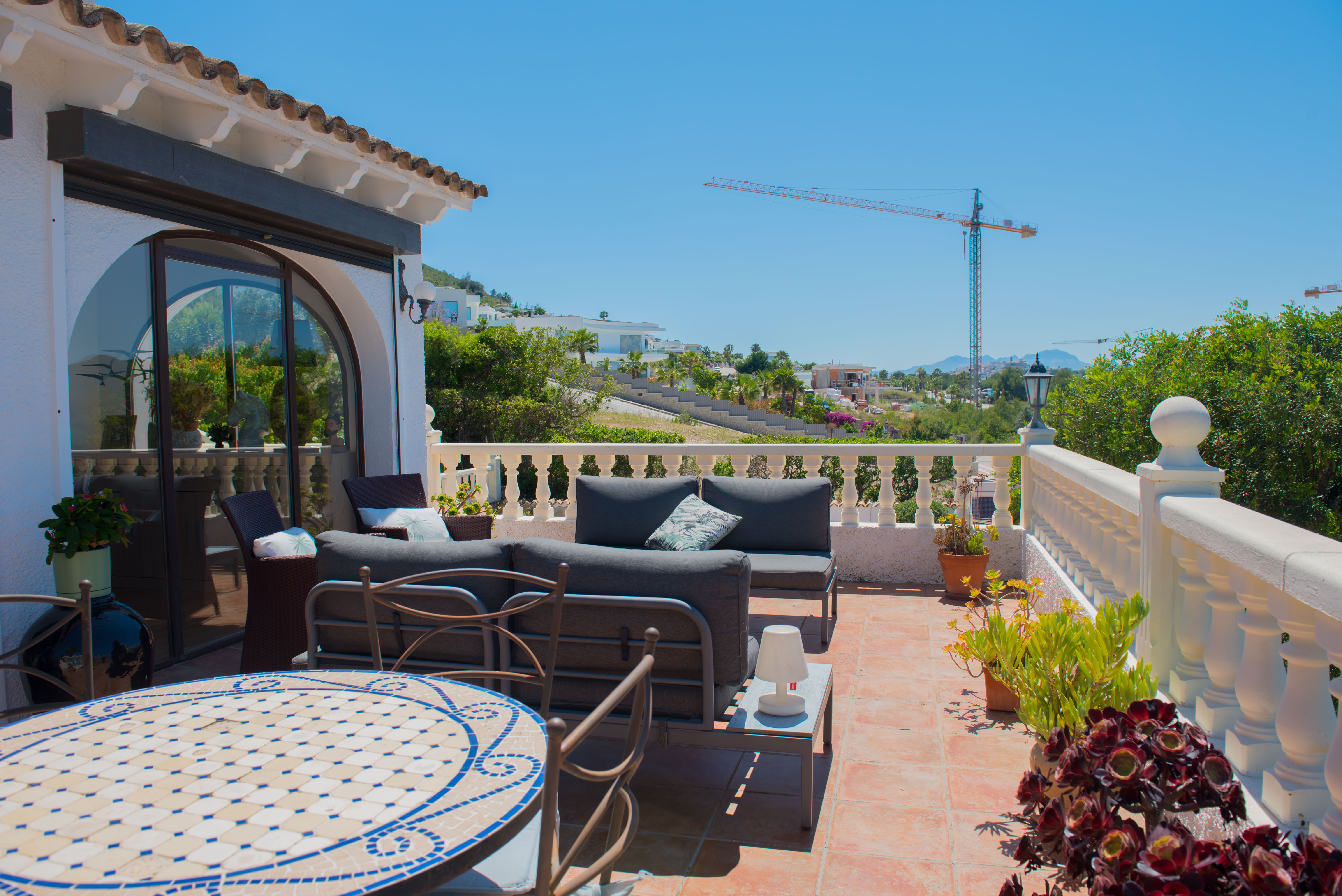 Terraza con suelo de terracota, barandilla blanca y vistas panorámicas.