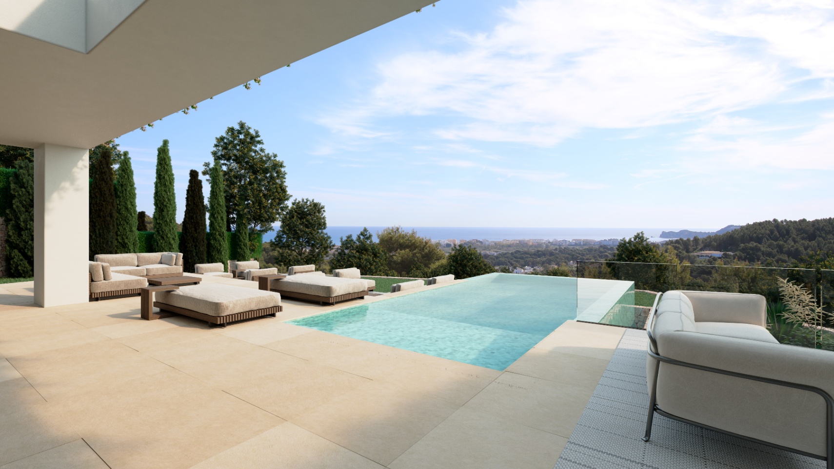 Terraza con suelo de piedra, piscina infinita con barandilla de cristal y mobiliario de exterior frente a vistas panorámicas del mar y la costa.