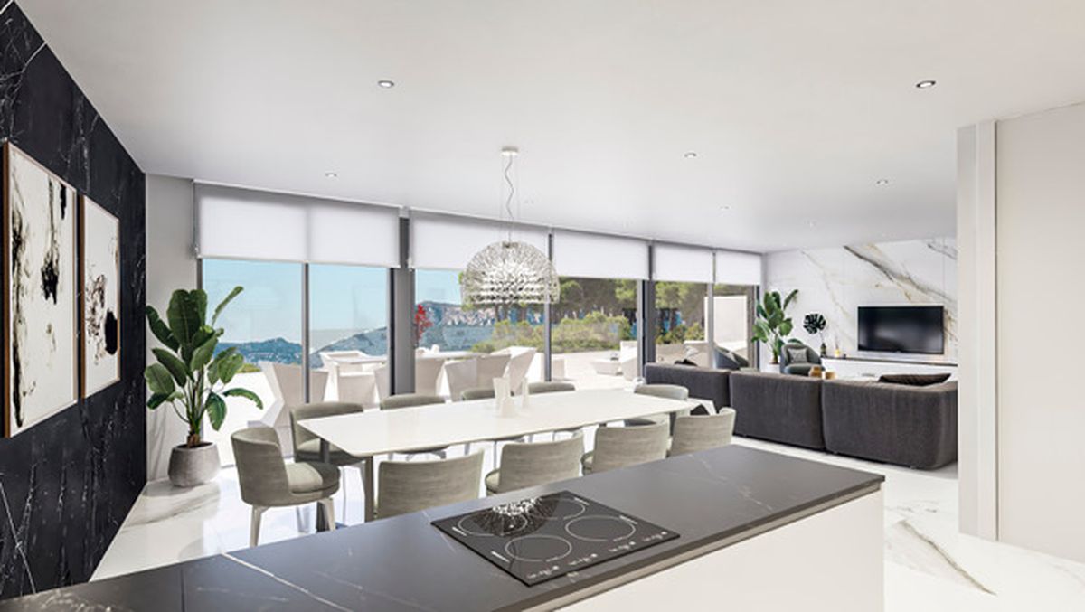 Zona de estar de planta abierta con mesa de comedor blanca, isla de cocina oscura y salón con paredes de efecto mármol y ventanales de suelo a techo.