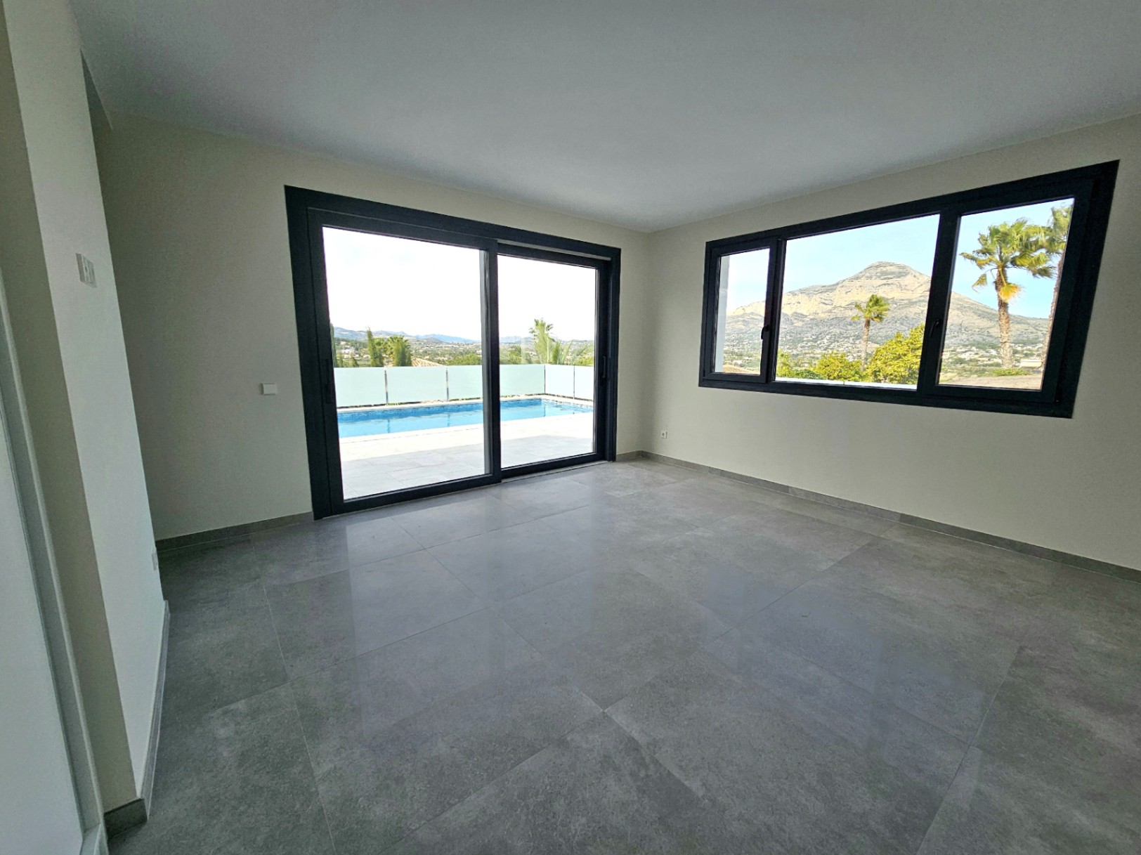 Habitación luminosa con suelo de gres y vistas a la piscina y al Montgó.