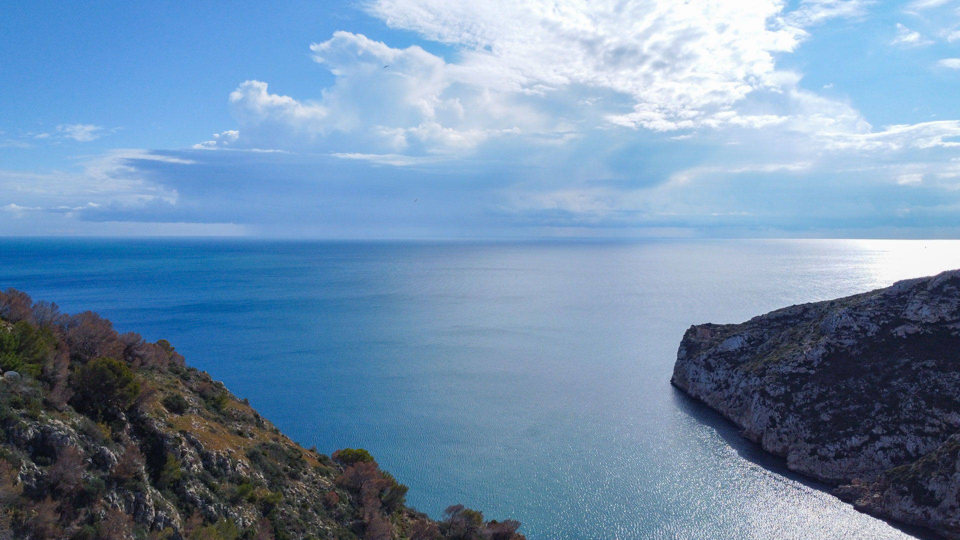 Vista panorámica del mar Mediterráneo y los acantilados de la zona de La Granadella en Jávea, destacando las aguas cristalinas y el entorno natural protegido.