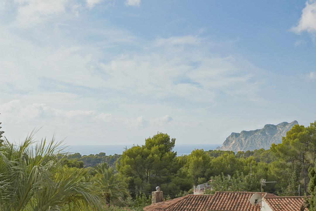Vistas panorámicas al mar Mediterráneo y al Peñón de Ifach desde la planta superior, rodeadas de un frondoso entorno de pinos y vegetación local.