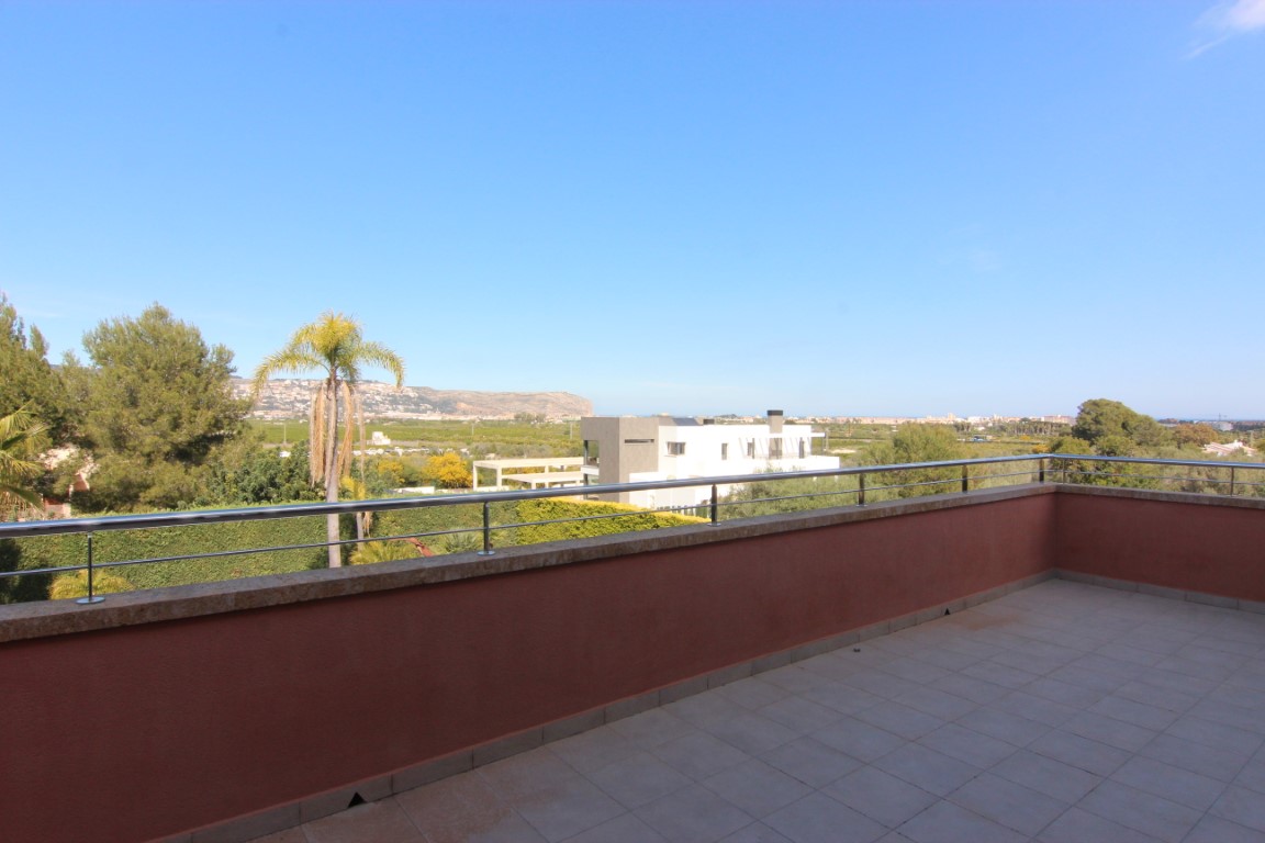Terraza en la planta superior con barandilla de acero inoxidable y vistas panorámicas despejadas hacia el valle y las montañas de Jávea.