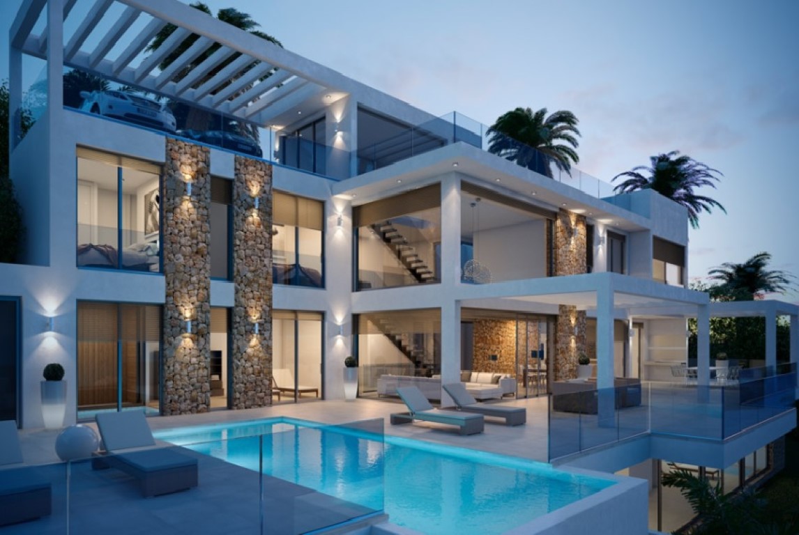 Fachada de tres niveles con piscina, muros de piedra seca y amplias terrazas de diseño contemporáneo iluminadas al anochecer.