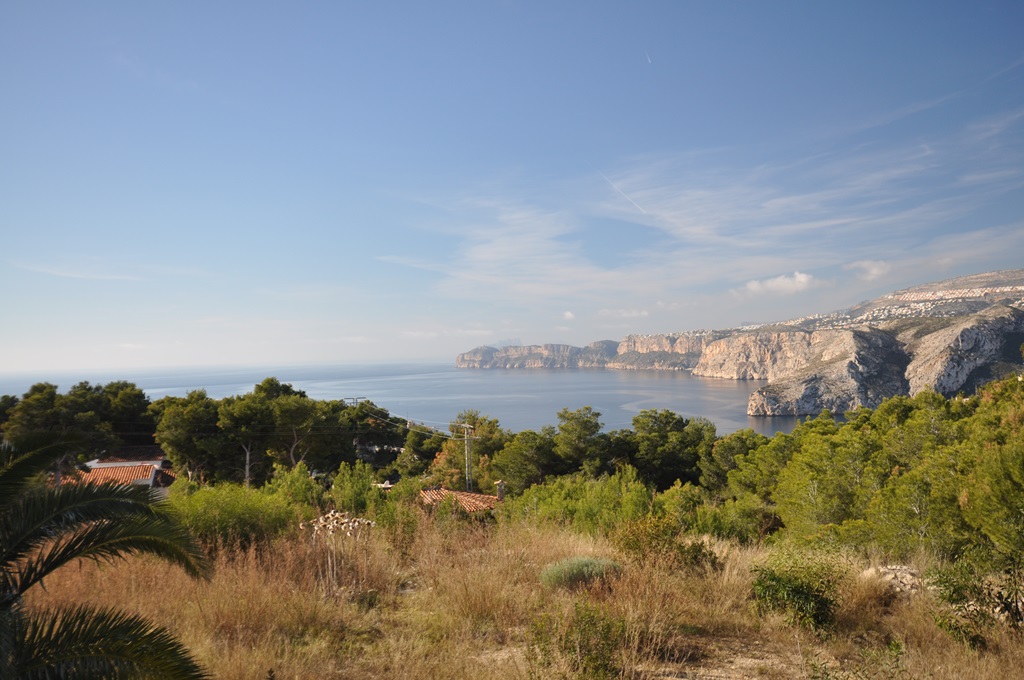 Vista panorámica desde la parcela hacia los acantilados de Jávea y el mar Mediterráneo, rodeada de vegetación autóctona y pinos.