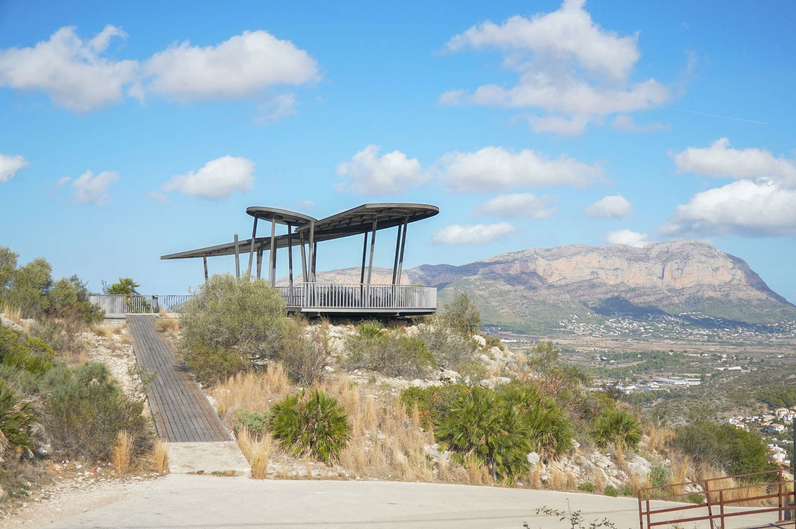 Mirador arquitectónico con pasarela de madera y estructura metálica, ofreciendo vistas panorámicas al valle y al macizo del Montgó en La Sella.