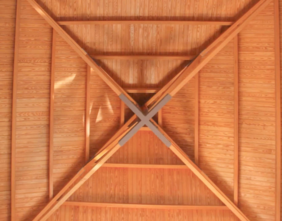 Detalle del techo de madera de alta calidad con estructura piramidal y vigas cruzadas centrales, aportando calidez y una arquitectura artesanal al espacio.