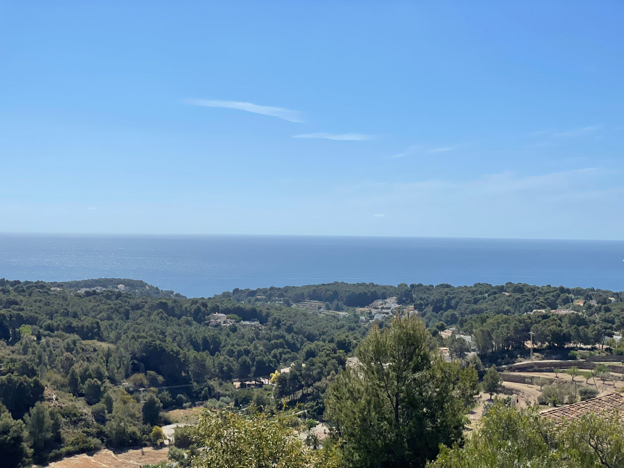 Vista panorámica desde la propiedad hacia el mar Mediterráneo, destacando la densa vegetación de pinos y el horizonte despejado de la costa de Benissa.