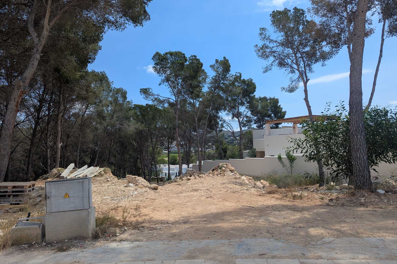 Parcela elevada rodeada de pinos maduros, lista para el inicio de la construcción con vistas despejadas y un entorno natural consolidado.