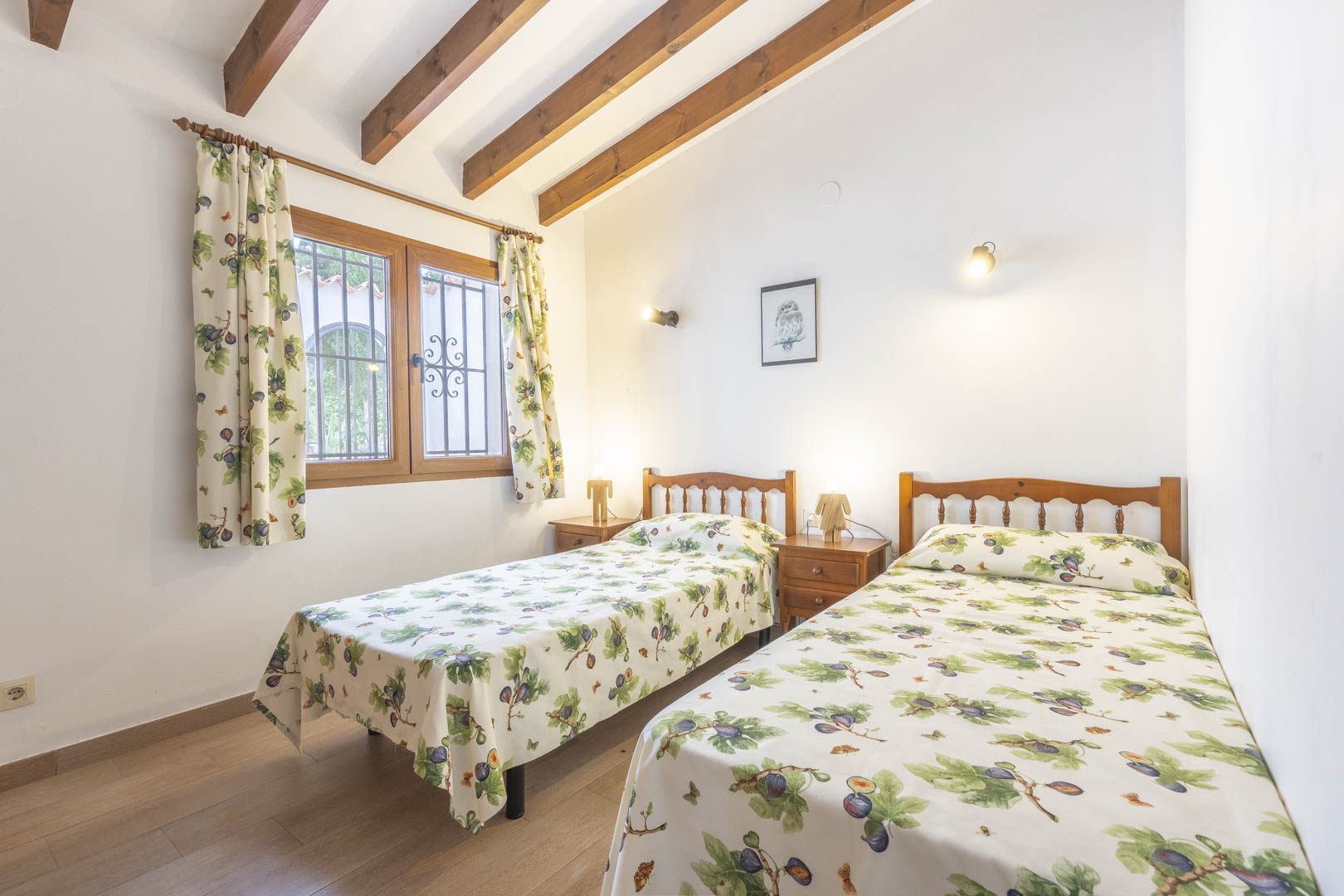 Dormitorio con dos camas individuales, vigas de madera vistas y decoración tradicional.
