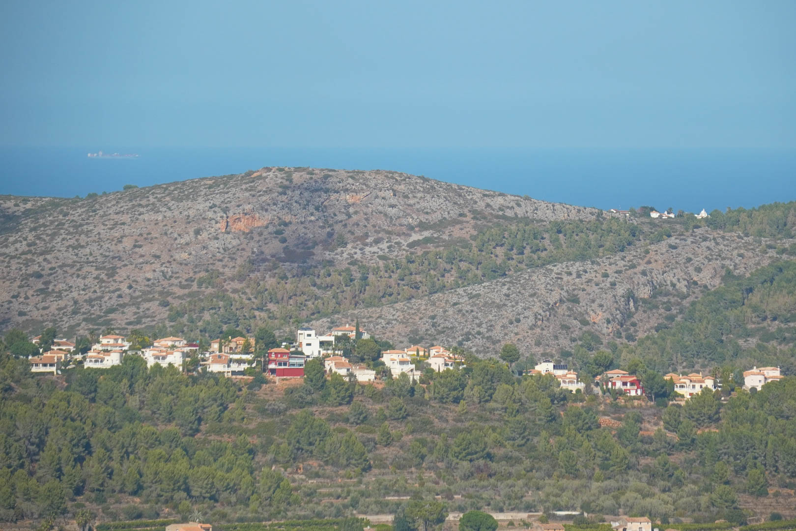 Vista panorámica desde la propiedad hacia el mar Mediterráneo y las montañas, mostrando la urbanización integrada en el paisaje forestal de Pedreguer.