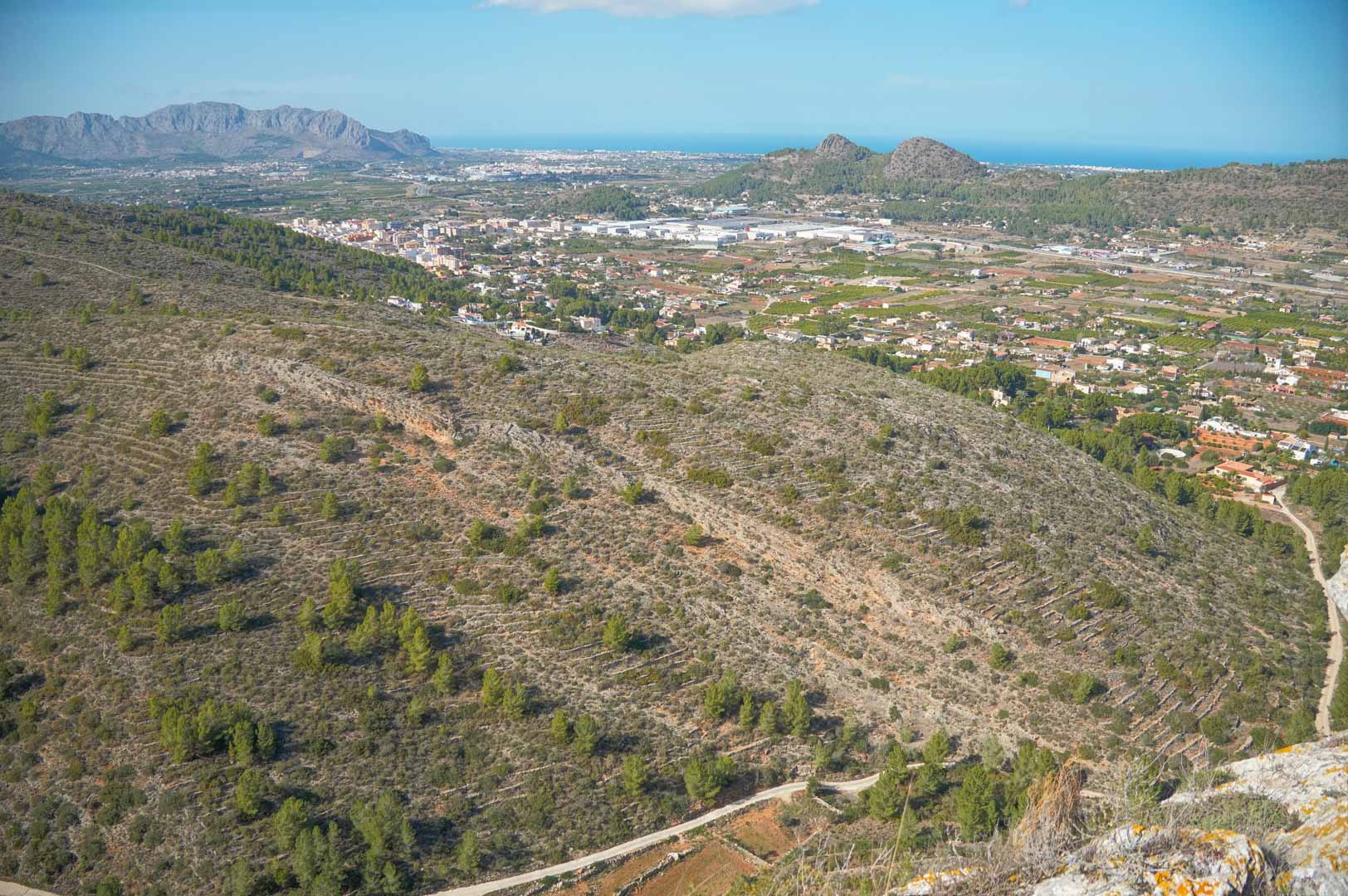 Vista panorámica desde la propiedad hacia el valle de Pedreguer, mostrando las montañas circundantes y el mar Mediterráneo en el horizonte bajo un cielo despejado.