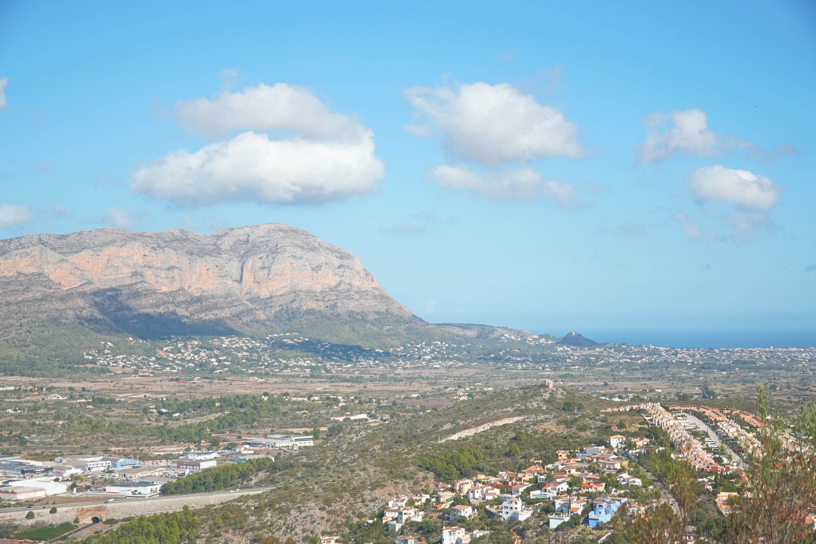 Vistas panorámicas desde la propiedad hacia el valle de Pedreguer, con el macizo del Montgó a la izquierda y el mar Mediterráneo en el horizonte bajo un cielo despejado.