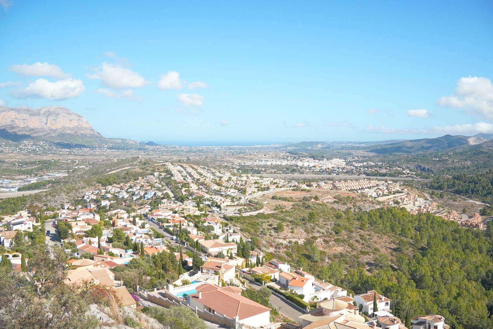 Vistas panorámicas desde la propiedad hacia el valle de Pedreguer, con el mar Mediterráneo en el horizonte y las montañas circundantes bajo un cielo despejado.