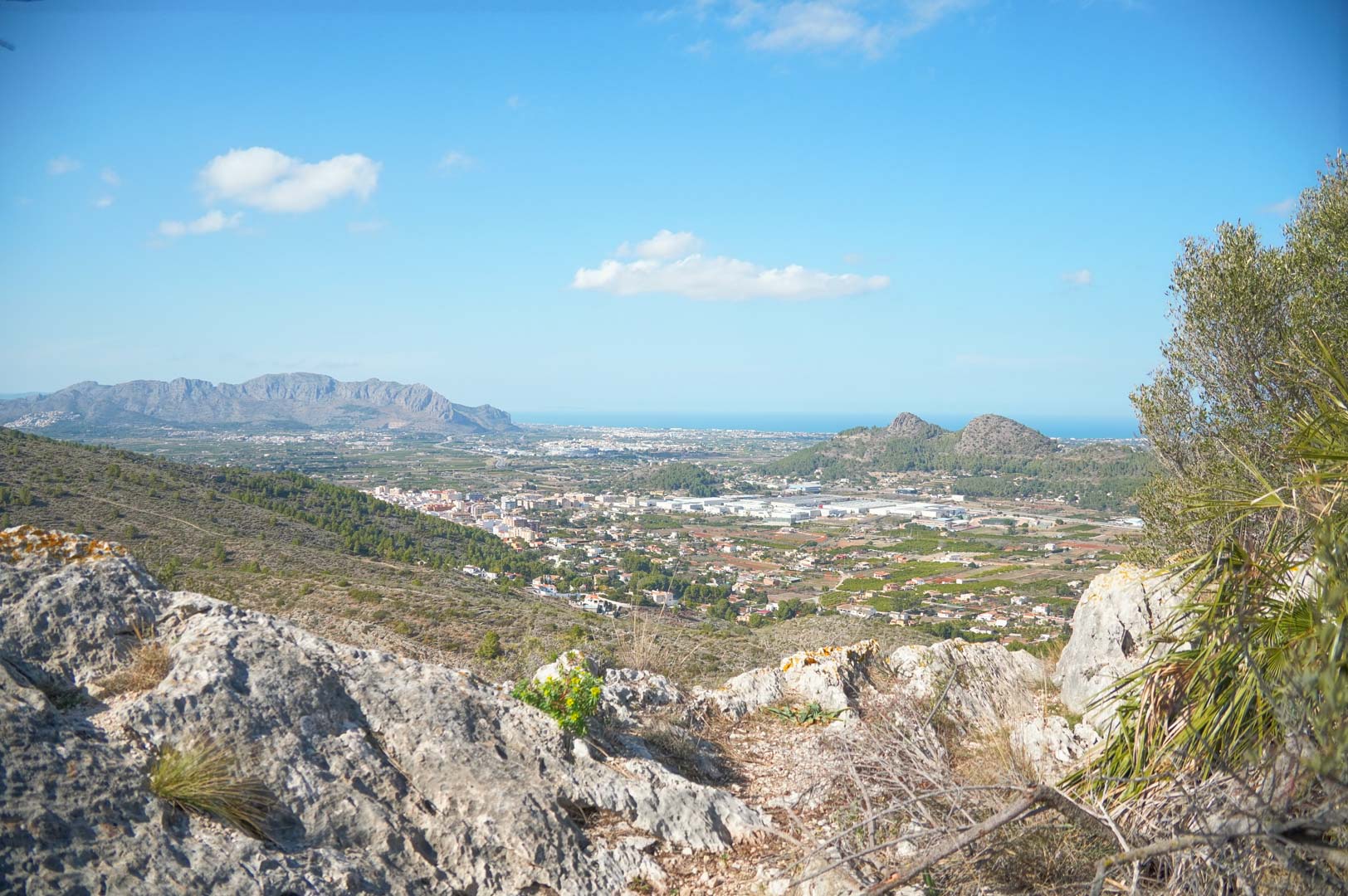 Vistas panorámicas desde la propiedad hacia el valle de Pedreguer, las montañas circundantes y el mar Mediterráneo en el horizonte bajo un cielo despejado.