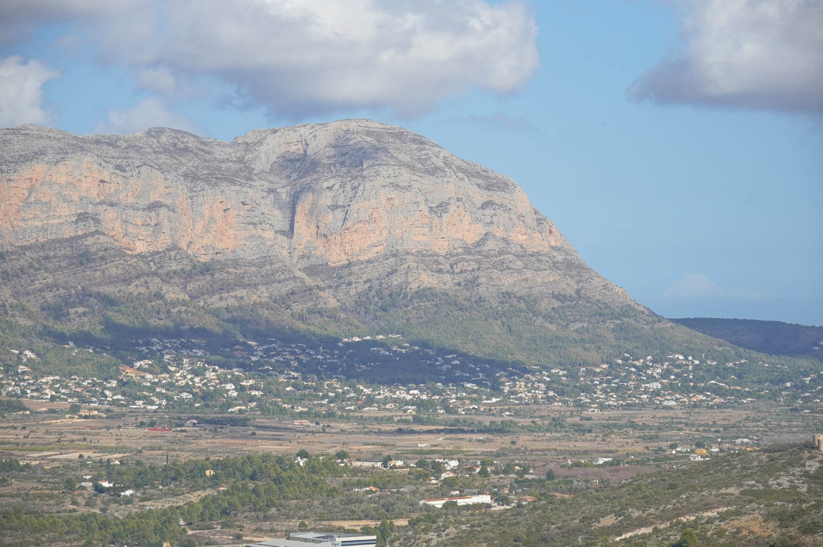 Vistas panorámicas desde la propiedad hacia el valle y el macizo montañoso, mostrando la integración de las zonas residenciales en el paisaje mediterráneo bajo un cielo despejado.