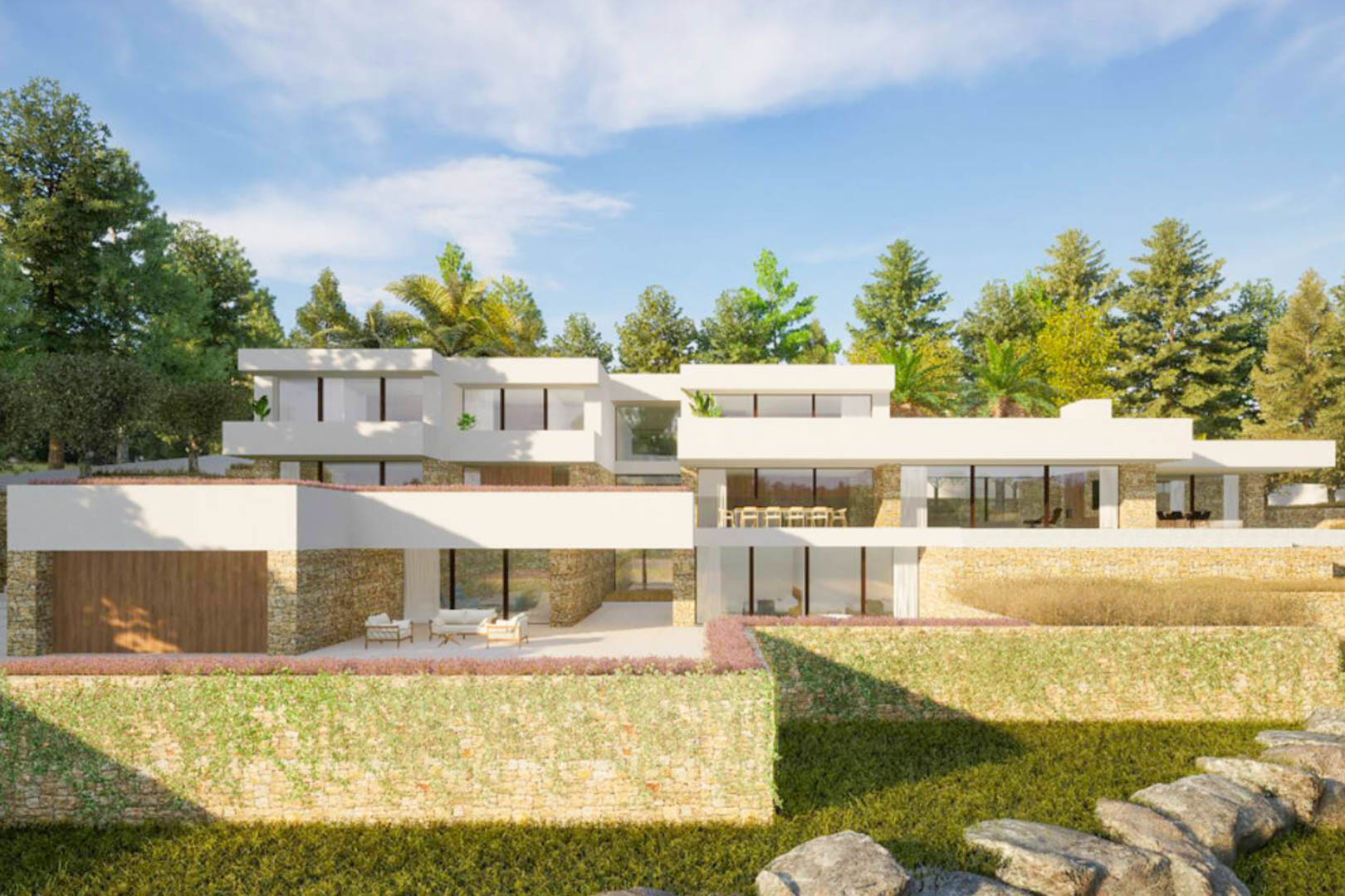 Fachada exterior de la villa con arquitectura de estilo ibicenco, combinando muros de piedra natural, amplios ventanales y terrazas integradas en un entorno paisajístico mediterráneo.