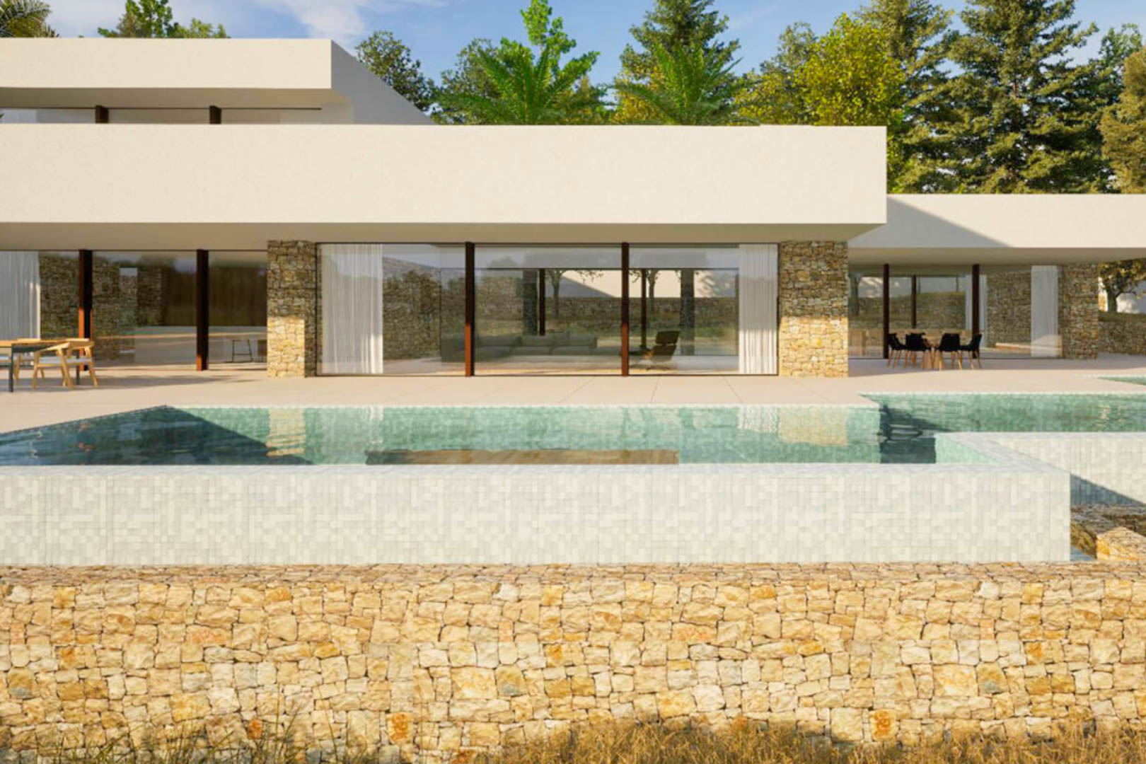 Fachada exterior de la villa con piscina desbordante de mosaico claro, muros de piedra natural y amplios ventanales que integran el salón con la terraza.