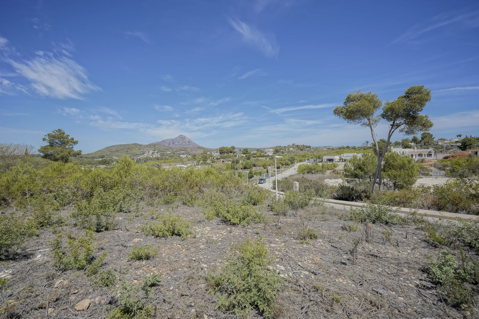 Vista panorámica desde la parcela hacia el macizo del Montgó, rodeada de vegetación mediterránea autóctona y cielos despejados en la zona de Valsol.