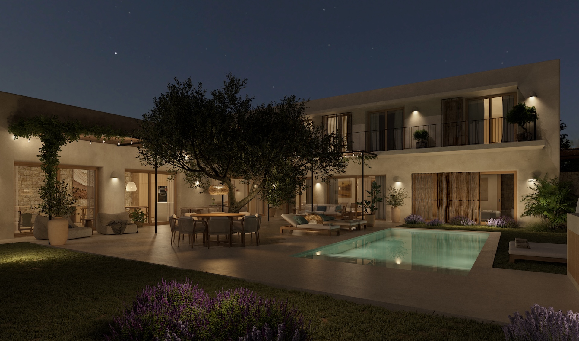 Vista nocturna del patio con piscina iluminada, comedor exterior bajo un árbol y fachada de la villa con balcones.