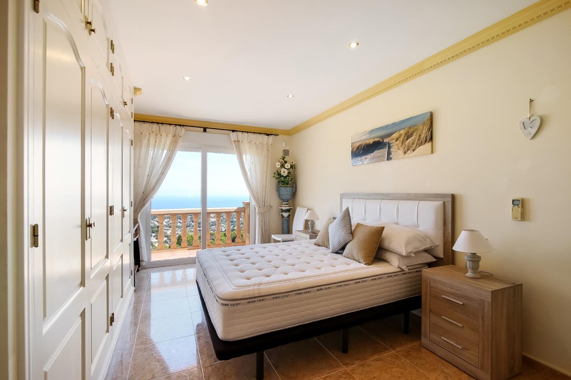 Dormitorio principal con armarios empotrados de pared a pared y acceso directo a una terraza con vistas al mar Mediterráneo.