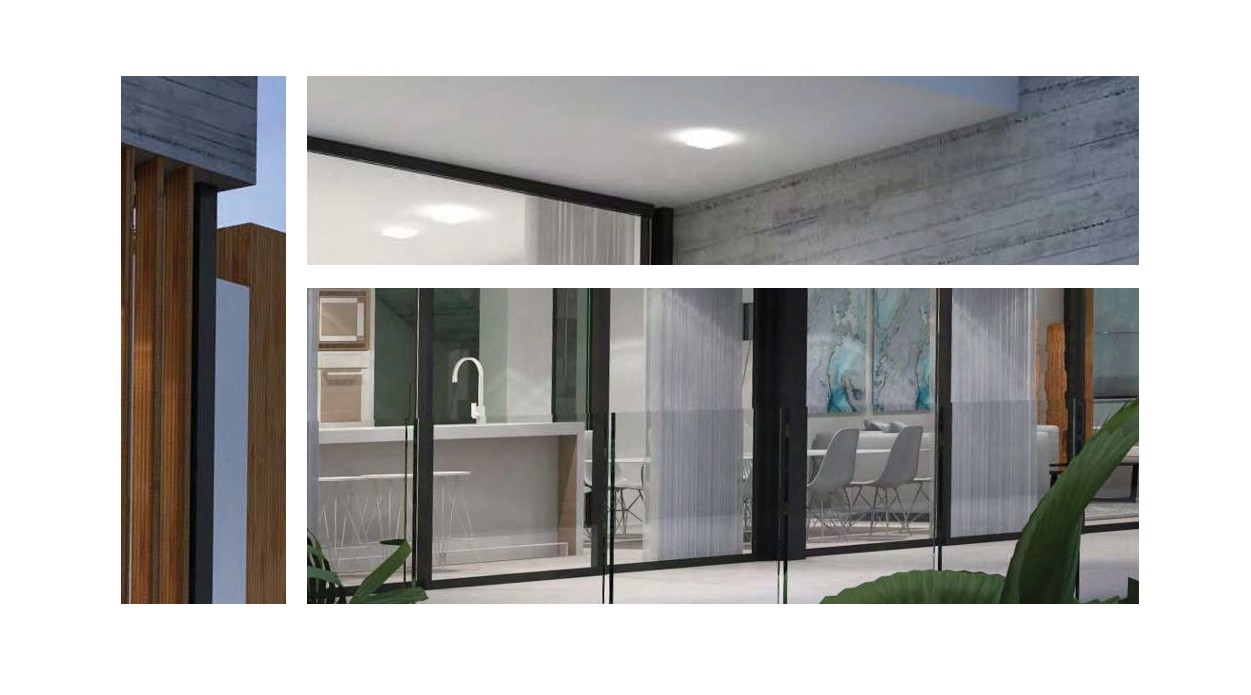 Vista exterior de la planta baja que muestra la cocina moderna con isla blanca y el comedor a través de amplios ventanales correderos y barandillas de cristal.