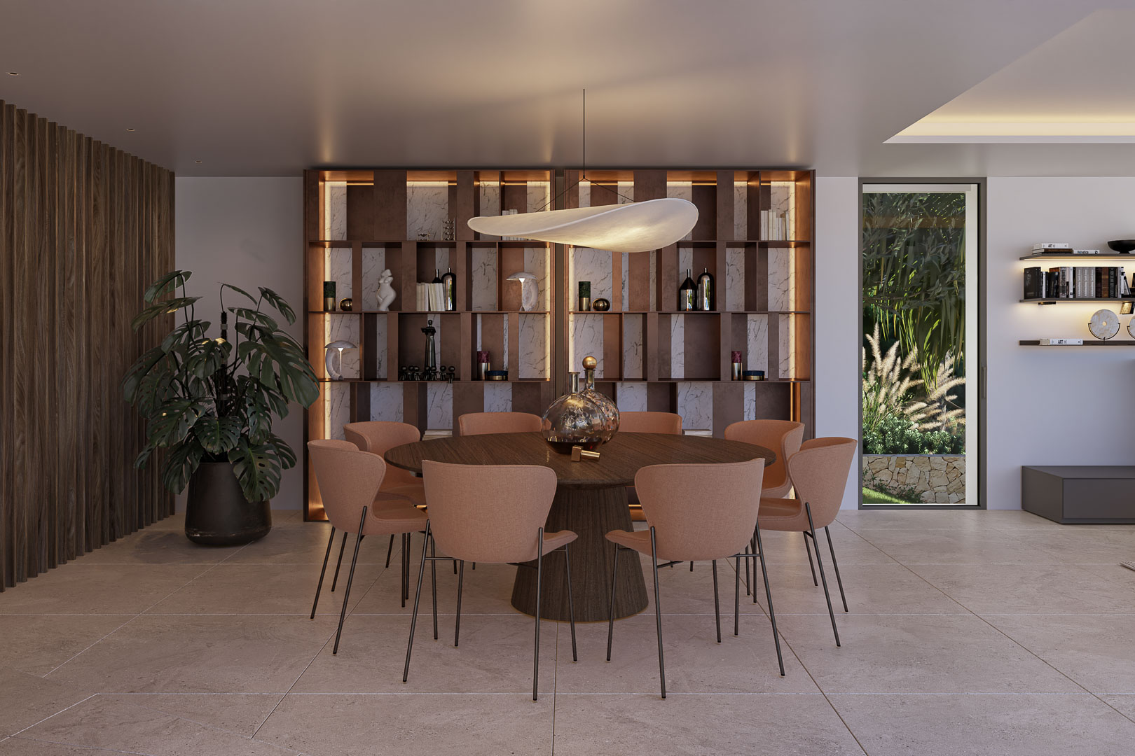 Comedor con mesa circular de madera, sillas tapizadas y lámpara escultural. Destaca la estantería integrada con fondo de mármol e iluminación LED y vistas al jardín.