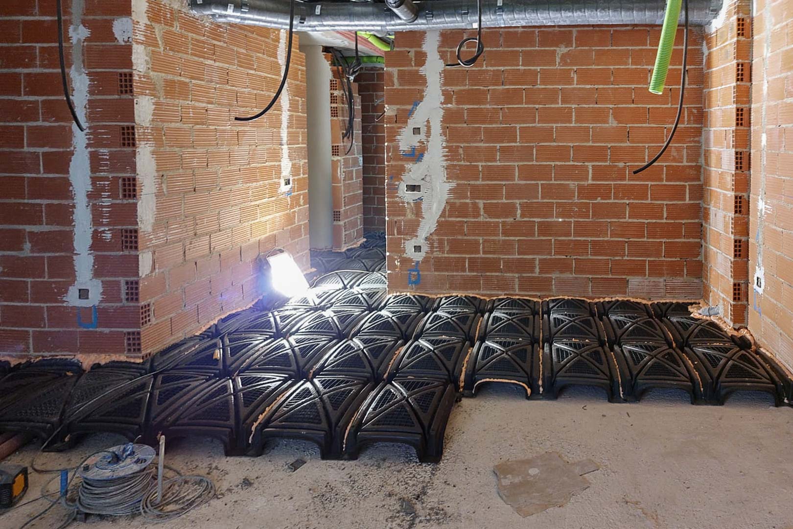 Fase de construcción mostrando la instalación del forjado sanitario con módulos de polipropileno para asegurar el aislamiento y la ventilación estructural.