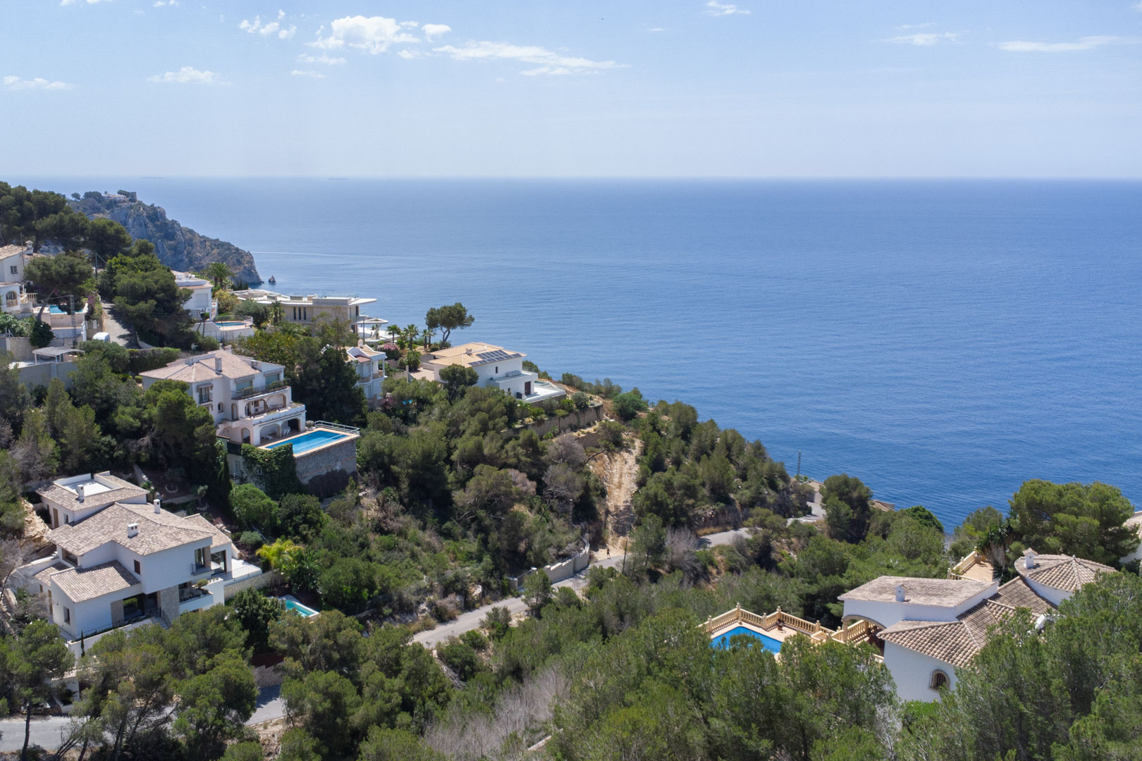 Vista aérea de la costa de Jávea mostrando villas mediterráneas rodeadas de pinos y vistas panorámicas al mar Mediterráneo desde la zona de Granadella.