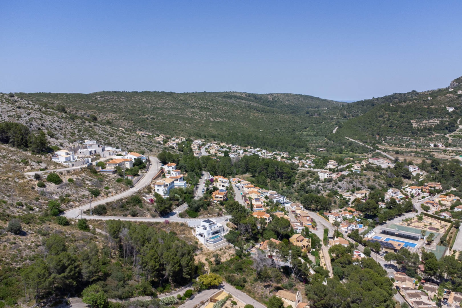 Vista aérea panorámica del Residencial VALL DE POP en Alcalalí, mostrando la ubicación elevada de las parcelas rodeadas de naturaleza y montañas en el valle de Jalón.