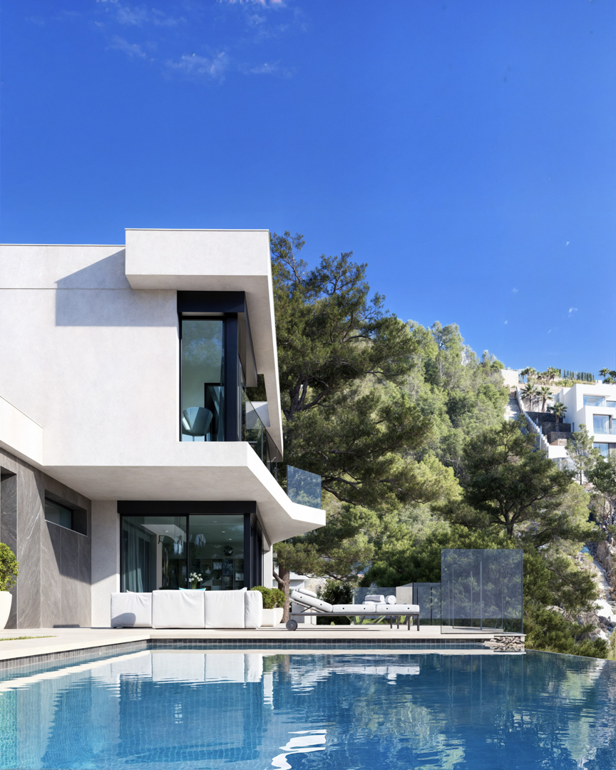Vista exterior de la villa con piscina infinita, fachada minimalista de estuco blanco y piedra gris, y amplios ventanales integrados en el entorno de pinos.