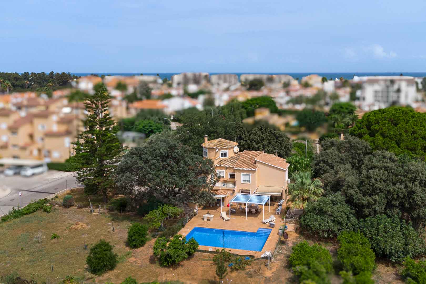 Vista aérea del chalet mediterráneo destacando su gran parcela llana, la piscina privada con zona de solárium y la proximidad al mar en Las Marinas de Dénia.